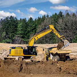 Image of excavator dumping dirt in to dump truck